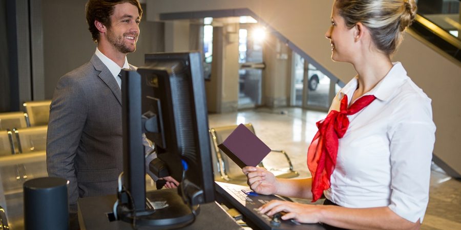 Businessman interacting with female airport staff at the check in desk in airport terminal